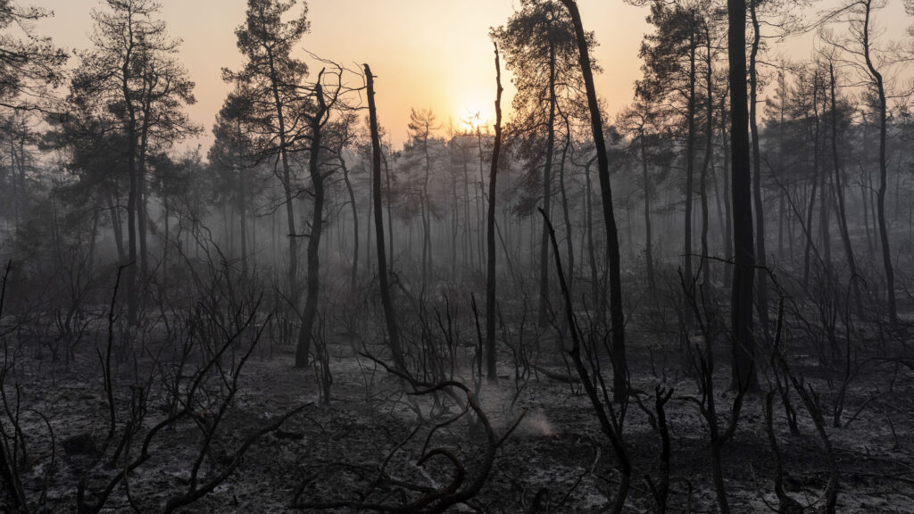 © Konstantinos Tsakalidis/SOOC, « Le soleil se couche derrière les montagnes brûlées, près du village de Gouves sur l’île d’Eubée, Grèce, le 10 Août 2021 », image tirée de la série « Greek Wildfires » | konstantinostsakalidis.com